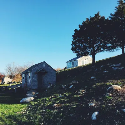 White And Brown House Near Green Trees Under Blue Sky During Daytime