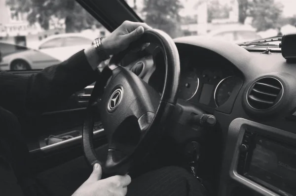Grayscale Photography Of Person Driving A Car