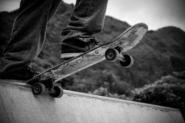 Person Standing On Skateboard Grayscale Photography