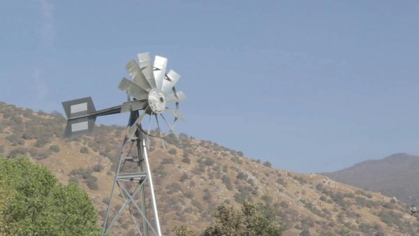 Windmill Spinning In A Mountainous Rural Landscape On A Clear Day. (Thumbnail)
