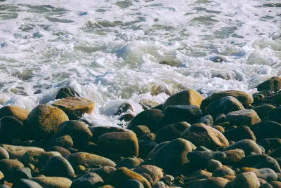 Brown And Black Rocks On Body Of Water