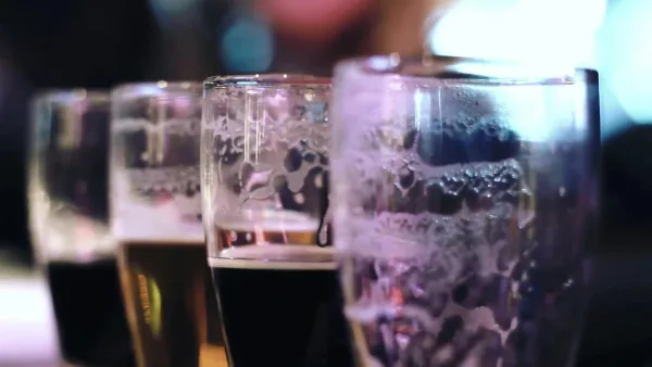Close-Up View Of Empty Frothy Beer Glasses In A Lively Bar Setting.