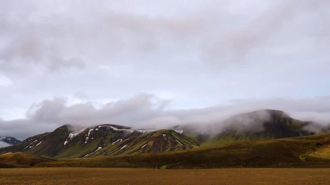 Breathtaking Timelapse Of Clouds Gracefully Moving Over Rugged Mountains.